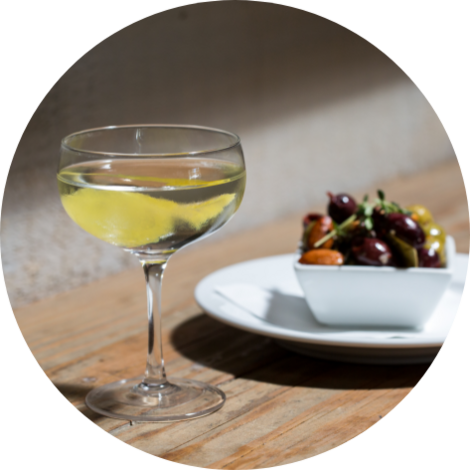 A glass of wine and a bowl of olives